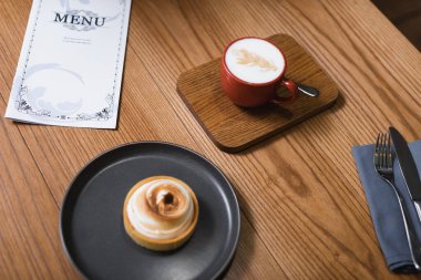 Masanın yanındaki limonlu turta ve kapuçino yüksek açılı görünüm 