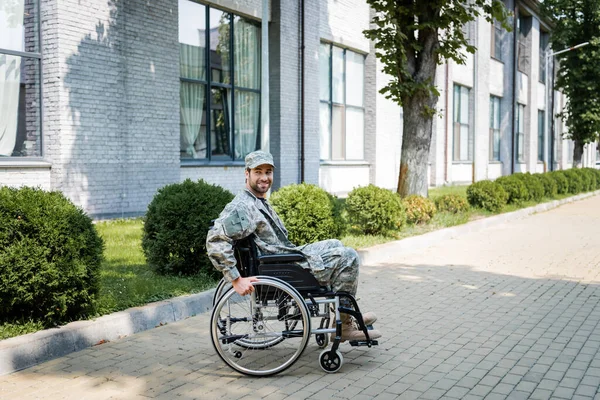 young handicapped veteran in wheelchair smiling on city street