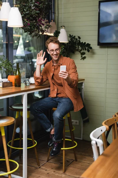 Happy Young Man Glasses Wireless Earphones Waving Hand Video Call — Stock Photo, Image