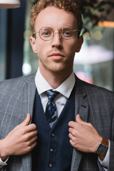 Bem Parecido Jovem Empresário Desgaste Formal Óculos Ajustando Blazer Café — Fotografia de Stock