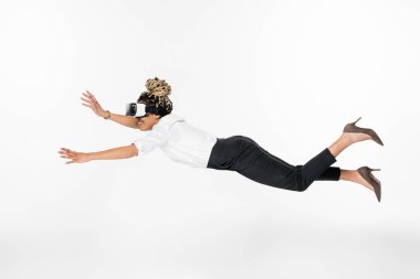 VR kulaklıkla uçan Afro-Amerikan iş kadınının beyaz üzerinde izole edilmiş görüntüsü 