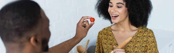 Alegre Mujer Afroamericana Cerca Borrosa Novio Con Tomate Cherry Cocina — Foto de Stock