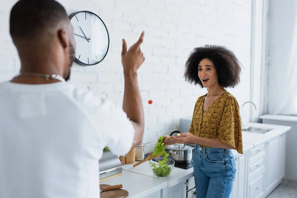 Amazed African American Woman Cooking Salad Boyfriend Throwing Cherry Tomato — Stock Photo, Image