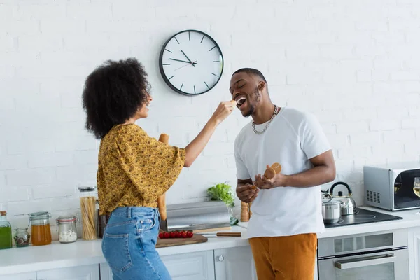 African American Woman Holding Baguette Boyfriend Open Mouth Kitchen — Stock Photo, Image