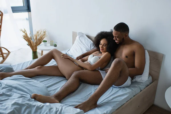 笑顔アフリカ系アメリカ人男巨大ガールフレンドでベッドの上に — ストック写真