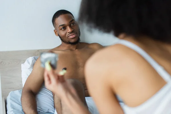 Africano Americano Homem Olhando Para Namorada Borrada Com Preservativo Quarto — Fotografia de Stock