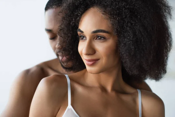 笑顔アフリカ系アメリカ人女性でブラジャー立っています近くにぼやけた白人のボーイフレンド — ストック写真