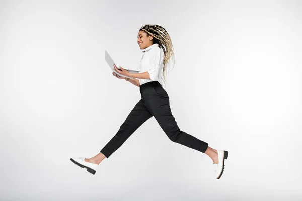 Sorridente Mulher Negócios Afro Americana Levitando Com Computador Isolado Branco — Fotografia de Stock