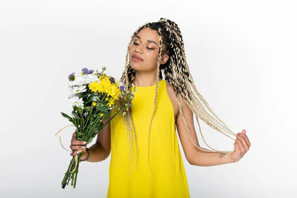 Pleased African American Woman Touching Dreadlocks While Looking Colorful Flowers — Stock Photo, Image