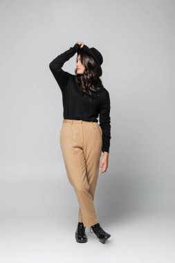 Fötr şapkalı ve gri elbiseli genç bir model.