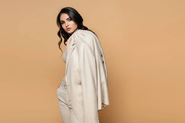 Hübsches Junges Model Hält Blazer Während Isoliert Auf Beige Posiert — Stockfoto