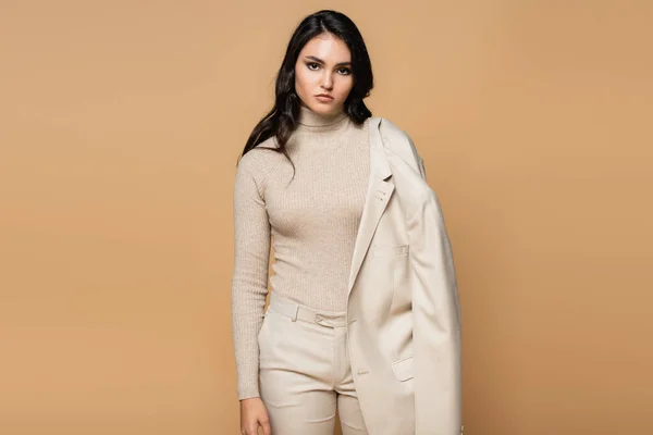 Bonito Modelo Cuello Alto Sosteniendo Chaqueta Posando Aislado Beige —  Fotos de Stock