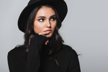 Siyah fötr şapkalı, balıkçı yakalı, gri yakalı, rüya gibi genç manken.