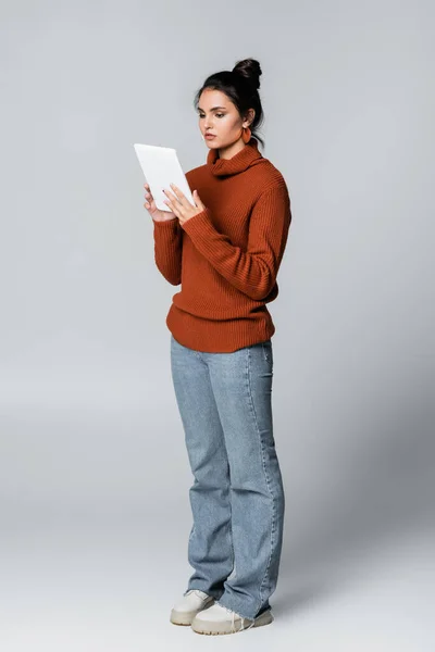 Junge Frau Strickpullover Und Jeans Mit Digitalem Tablet Auf Grau — Stockfoto