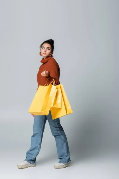 Full Length Young Woman Sweater Jeans Walking Yellow Shopping Bags — Stock Photo, Image