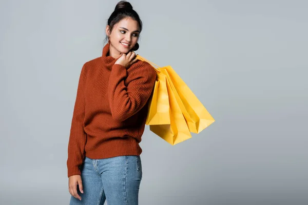 회색에 고립된 노란색 쇼핑백을 청바지와 스웨터를 — 스톡 사진