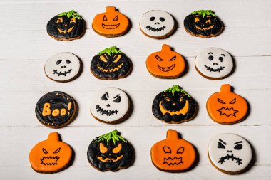 high angle view of homemade and spooky halloween cookies on white surface clipart