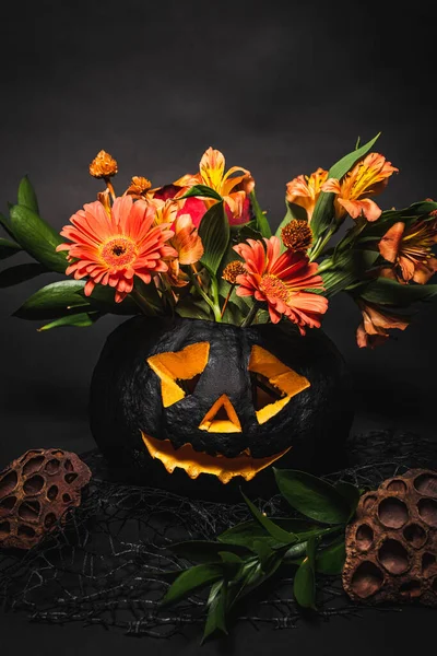 Orange Flowers Green Leaves Spooky Carved Pumpkin Black Background — Stock Photo, Image