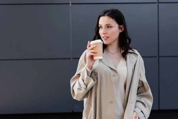 Brunette Woman Beige Raincoat Looking Away While Standing Takeaway Drink — Stock Photo, Image