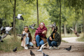 Glückliche Araberin zeigt auf vergrabene Vögel im Park 