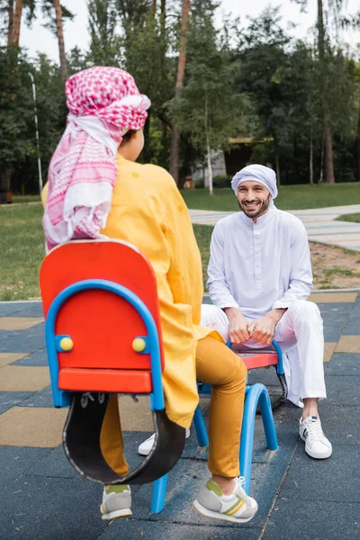 Smilende Muslimske Far Tilbringer Tid Med Søn Legeplads - Stock-foto