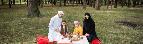 Sonriente Familia Musulmana Mirando Cámara Cerca Comida Parque Pancarta —  Fotos de Stock