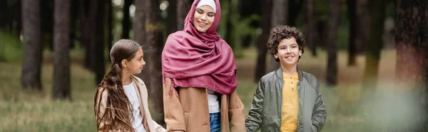 Alegre Menino Muçulmano Andando Perto Mãe Irmã Parque Banner — Fotografia de Stock