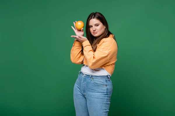 Mooie Vrouw Met Overgewicht Houden Oranje Kijken Naar Camera Geïsoleerd — Stockfoto