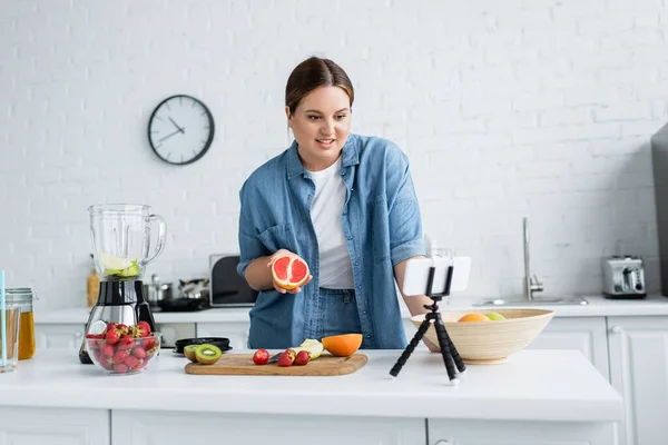 Smiling Size Woman Holding Grapefruit Fruits Smartphone Kitchen — Stock Photo, Image