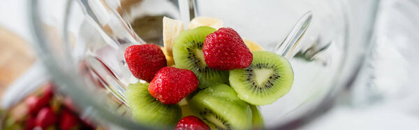 High angle view of fresh fruits in blender in kitchen, banner 