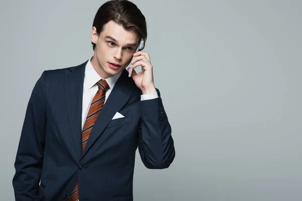 Junger Geschäftsmann Anzug Spricht Auf Smartphone Isoliert Auf Grau — Stockfoto