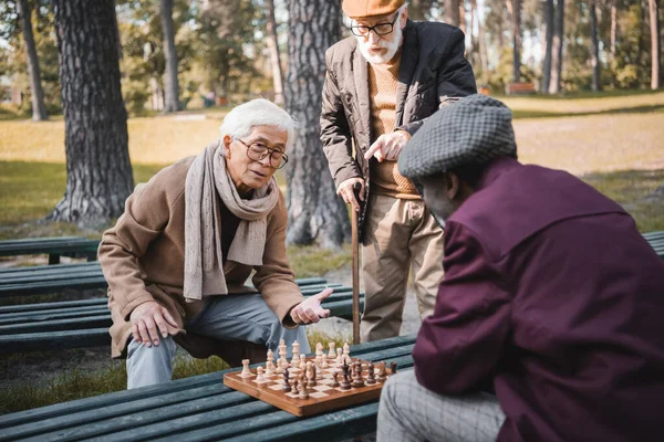 Senior Interracial Friends Playing Chess Friend Pointing Finger Park — Stock Photo, Image