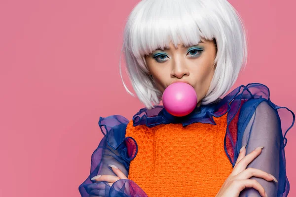 时尚的亚洲模型吹泡泡糖 看着被粉色隔离的相机 — 图库照片