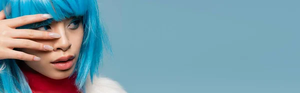 Młoda Azjatycka Kobieta Peruce Odwracając Wzrok Dotykając Twarzy Odizolowany Niebieskim — Zdjęcie stockowe