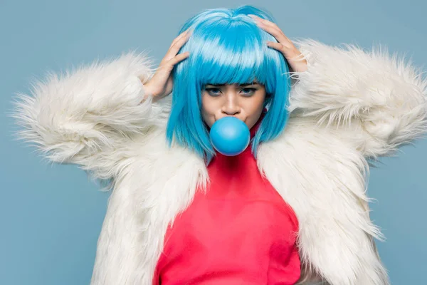 年轻的亚洲流行艺术女人在吹蓝色泡泡糖的时候碰了碰假发 — 图库照片