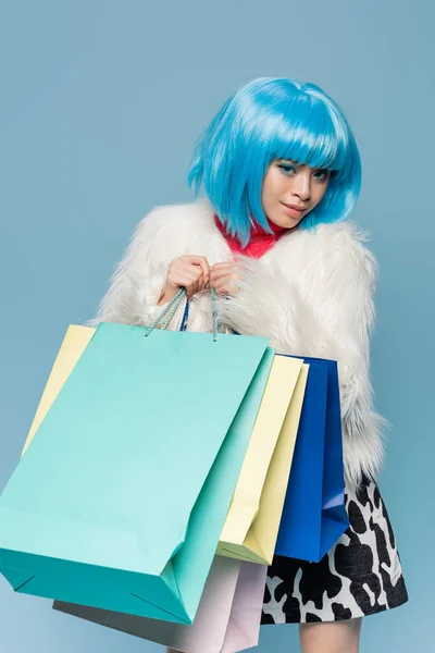 Jovem Mulher Asiática Brilhante Peruca Segurando Sacos Compras Isolados Azul — Fotografia de Stock