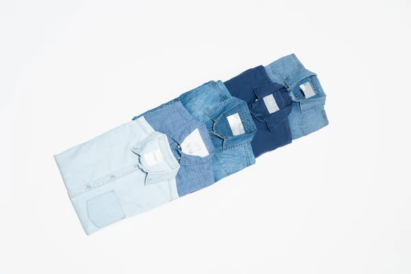 Plano conjunto de camisas de mezclilla azul sobre fondo blanco, vista superior - foto de stock