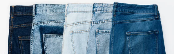 Fila orizzontale di jeans vari isolati su bianco, vista dall'alto, banner — Foto stock