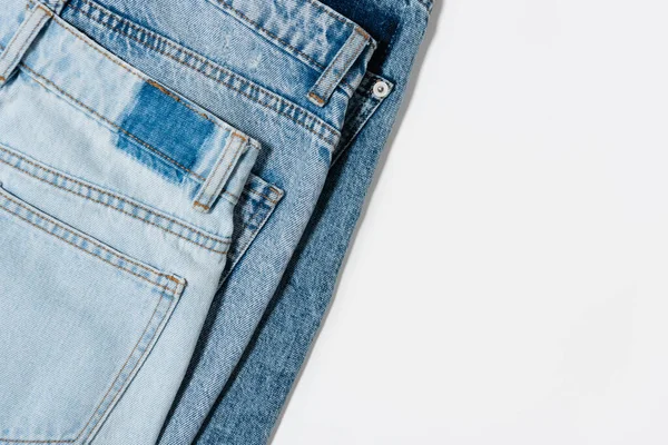 Vue de dessus de divers jeans bleus sur fond blanc — Photo de stock