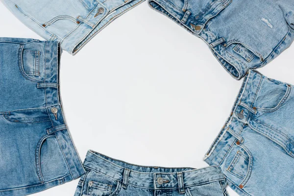 Cadre vide fabriqué à partir de divers jeans bleus sur fond blanc, vue de dessus — Photo de stock