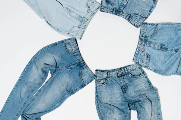 Ansicht des leeren Rahmens von verschiedenen blauen Jeans auf weißem Hintergrund — Stockfoto