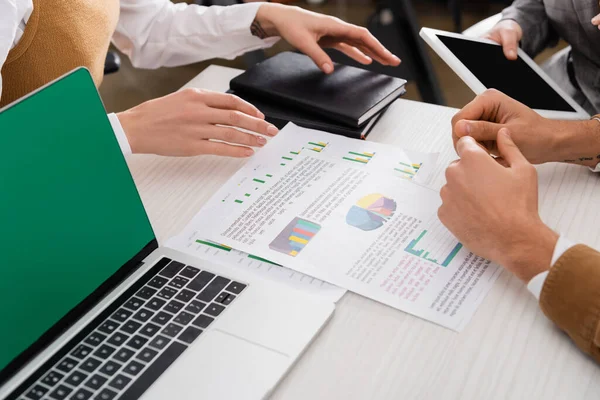 Cropped view of businesspeople working with devices and papers in office — Stock Photo