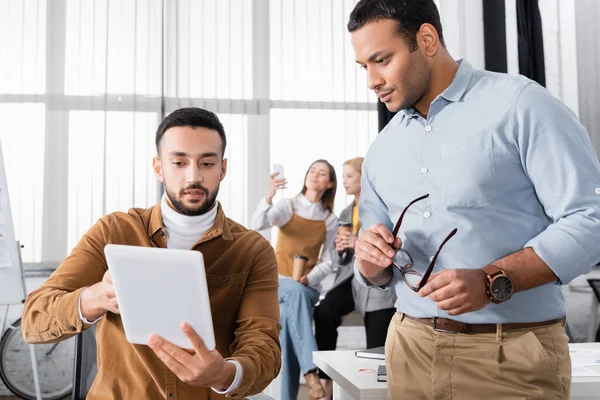 Arabischer Geschäftsmann zeigt indischem Amtskollegen digitales Tablet — Stockfoto