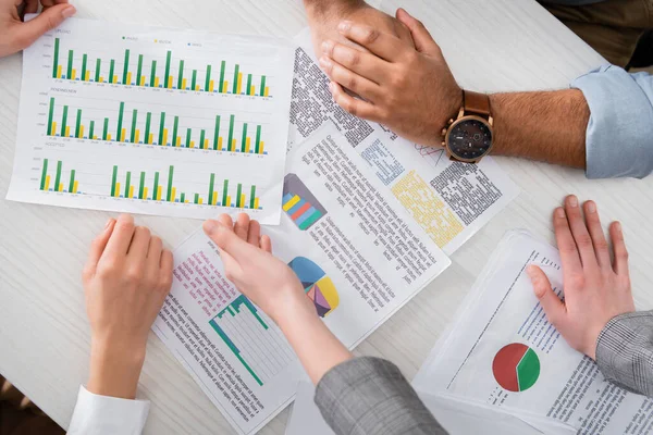 Cropped view of businesspeople analyzing charts on papers — Stock Photo