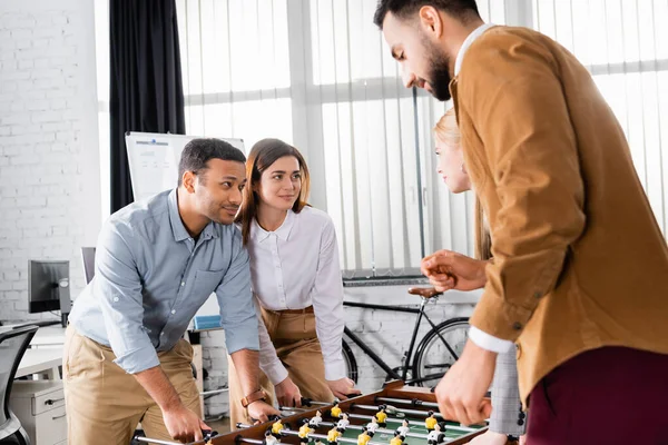 Imprenditori multiculturali che si guardano vicino al calcio balilla in ufficio — Foto stock