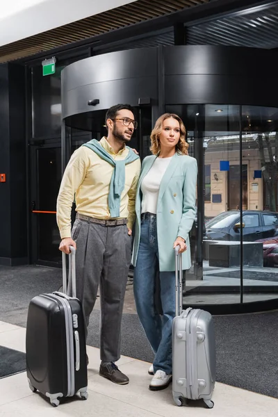 Jeunes voyageurs interracial avec valises en attente près de l'hôtel — Photo de stock