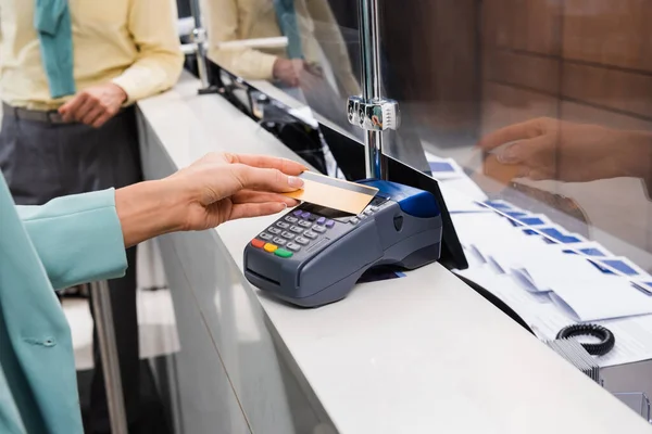 Vista recortada de la mujer que paga con tarjeta de crédito en la recepción del hotel - foto de stock