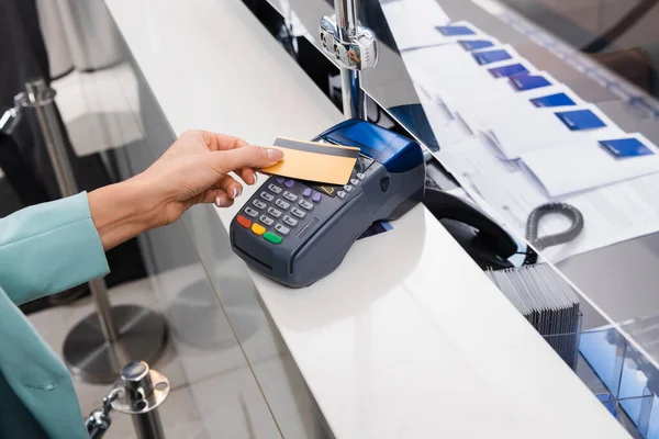 Vista recortada de la mujer que paga con tarjeta de crédito y terminal de pago en el hotel - foto de stock