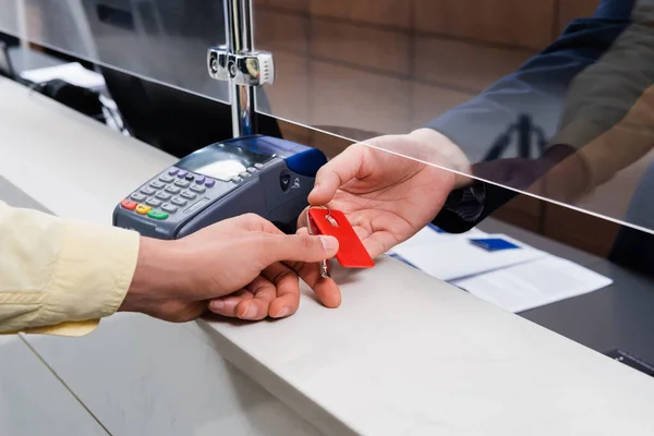 Ausgeschnittene Ansicht eines Mannes, der dem Hotelmanager in der Lobby Schlüssel abnimmt — Stockfoto