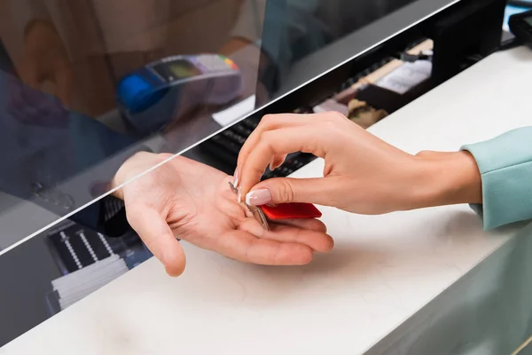 Vista ritagliata della donna che prende la chiave dalla receptionist in hotel — Foto stock